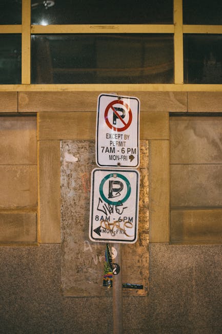 A weathered metal sign mounted on a blue pole, attached to a white wall, displays the text 'THIS SPACE RESERVED 24 HOURS' in white capital letters. The sign shows signs of rust and peeling paint, with